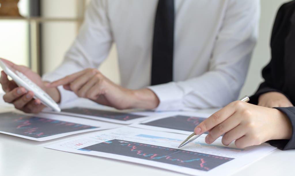 Un investisseur examinant des graphiques financiers et des plans immobiliers à Dubaï.