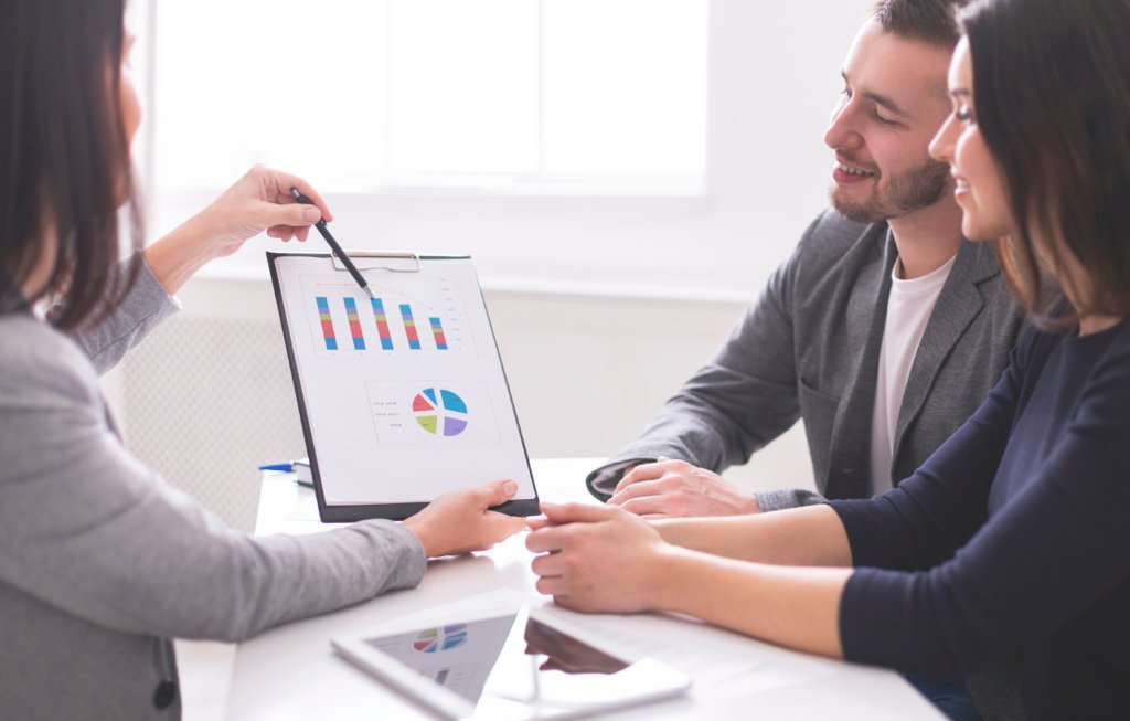 Conseiller immobilier présentant des plans de paiement à un investisseur.