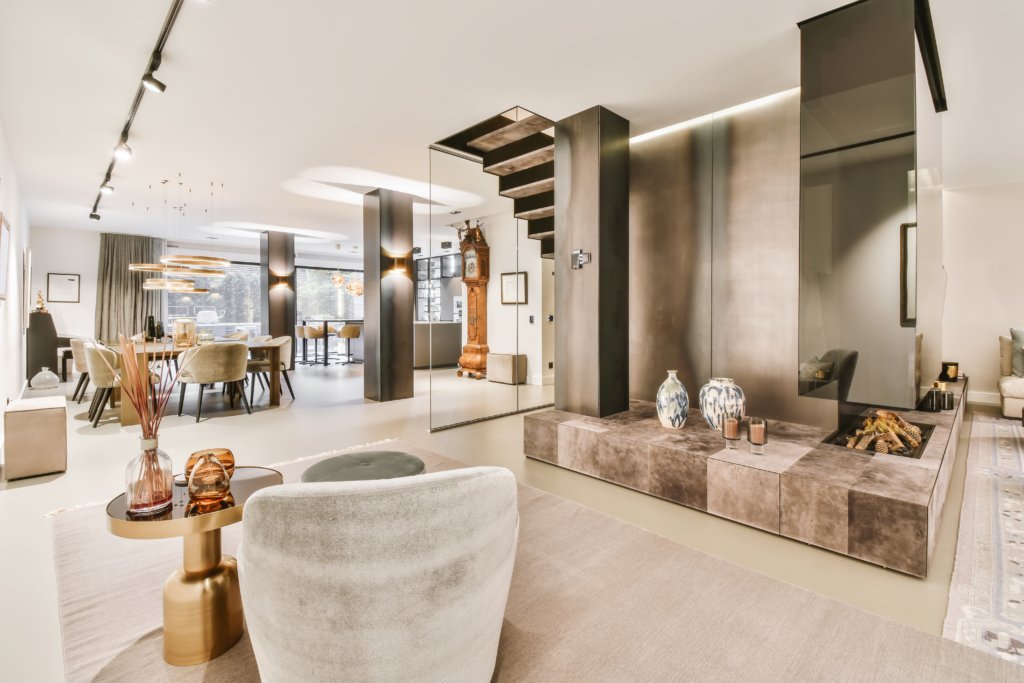 Spacious and stylish dining room featuring a sleek black table surrounded by soft gray upholstered chairs, showcasing a modern and elegant interior design perfect for upscale living spaces.