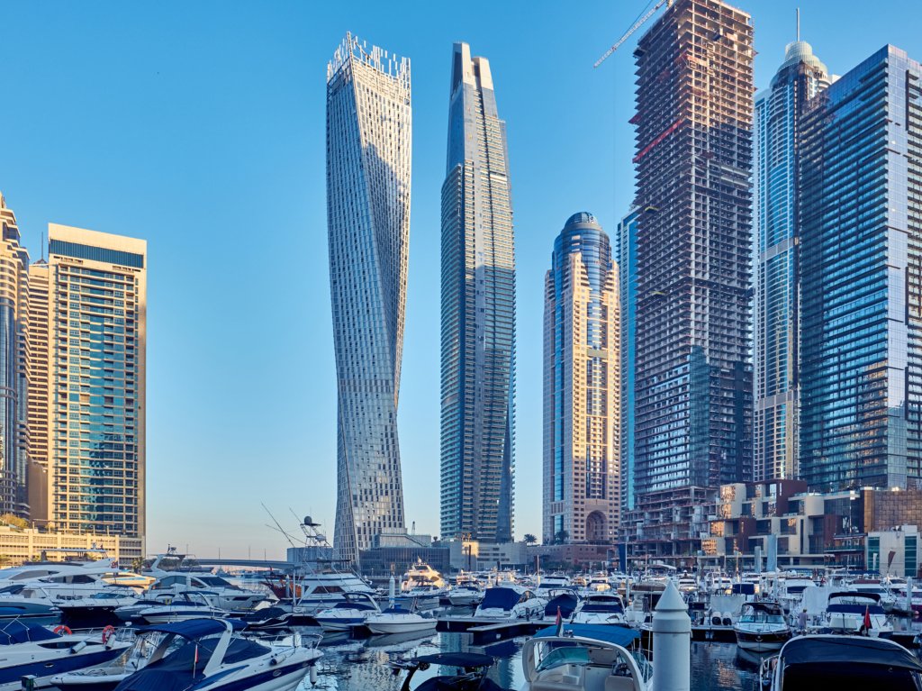 Vue diurne de la skyline de Dubaï Marina, mettant en avant les tours résidentielles modernes, les yachts amarrés le long du canal, et l’ambiance luxueuse de ce quartier emblématique situé au bord du golfe Persique.