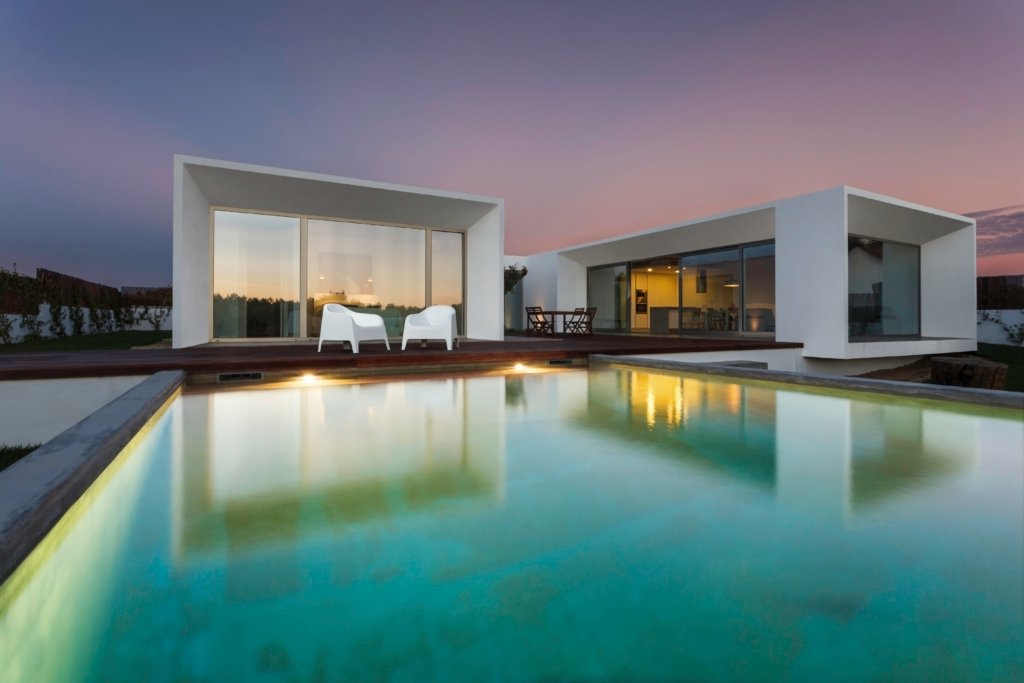 Maison contemporaine avec lignes épurées, entourée d’un jardin paysager, d’une piscine privée et d’une terrasse en bois, illustrant un cadre de vie haut de gamme alliant confort, design et nature.